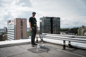 Fallsikring i bruk på flatt tak tekket med asfalt/takpapp.